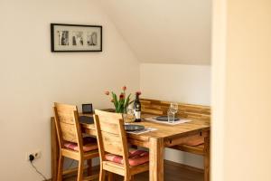 a dining room table with chairs and a bottle of wine at am Hohlebach in Schliengen