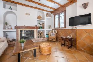 a living room with a fireplace and a tv at Casa El Valle Verde Granada in Lecrin
