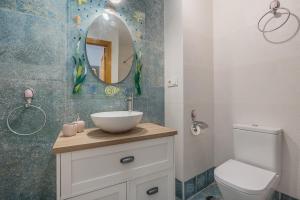 a bathroom with a sink and a toilet and a mirror at Casa El Valle Verde Granada in Lecrin +19 photos