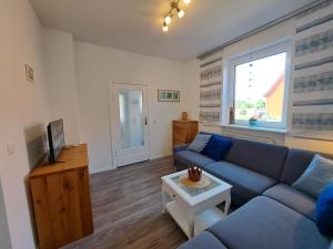 a living room with a blue couch and a tv at Ferienhaus Mandelbäumchen in Barth