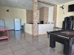 a room with a ping pong table and a refrigerator at Casa com piscina em Maringá in Maringá +11 photos