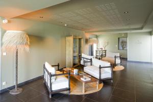 a living room with chairs and a table and a lamp at Domaine du Boisniard in Chambretaud