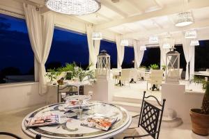 a dining room with a glass table and chairs at Tenuta Del Poggio Antico in Ischia