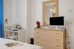 a bedroom with a dresser with a television on it at Camera Meridiana in Roncone +14 photos