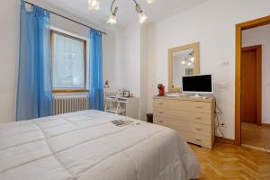 a bedroom with a bed and a dresser with a television at Camera Meridiana in Roncone