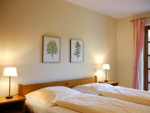 two beds in a bedroom with two lamps on the wall at Ferienhaus Straubehof in Sasbachwalden +35 photos