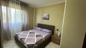 a bedroom with a bed with purple pillows and a window at Appartamento Ely in Pioltello