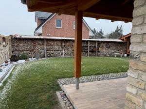 a backyard with a stone wall and a wooden deck at Villa Toscana in Teltow