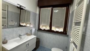 a bathroom with a sink and a toilet and windows at Appartamento Ely in Pioltello +10 photos