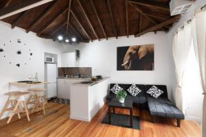 a kitchen and living room with white walls and wooden ceilings at Casa Rural tacoronte in Tacoronte