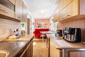 a kitchen with wooden cabinets and a red couch at Fewo mit Terrasse Moritzburg in Moritzburg