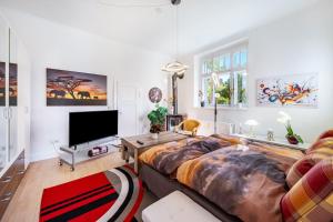 a living room with a large bed and a tv at Fewo mit Terrasse Moritzburg in Moritzburg
