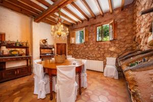 a dining room with a table and a stone wall at Sa Cabana d'es Vicari in Fornalutx