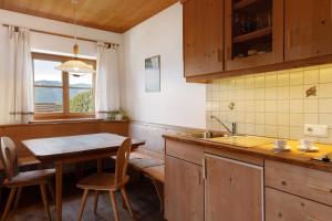 a kitchen with a table and a sink and a window at Rielingerhof in Collalbo +107 photos