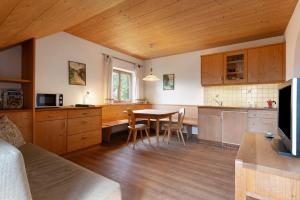 a kitchen with a table and chairs in a room at Rielingerhof in Collalbo
