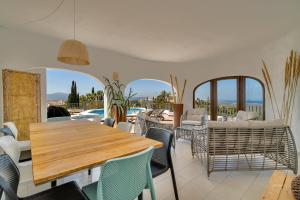 a dining room with a wooden table and chairs at Villa Amalia in Denia