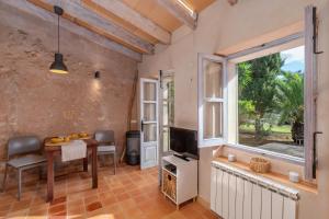 a living room with a table and a window at Casa Groc in Costitx