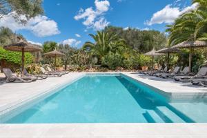 a swimming pool with chairs and umbrellas at Casa Groc in Costitx