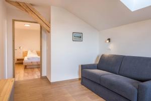 a living room with a couch and a bedroom at Nigglhof Apartment Katarina in Redagno