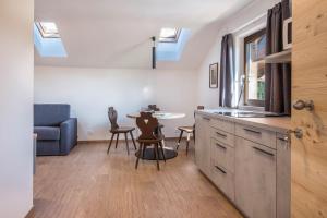 a kitchen with skylights and a table and chairs at Nigglhof Apartment Katarina in Redagno