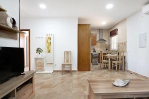 a large living room with a tv and a kitchen at Chalet Rural El Chorrillo in Conil de la Frontera