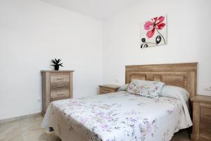 a bedroom with a bed with a flower on the wall at Chalet Rural El Chorrillo in Conil de la Frontera +20 photos