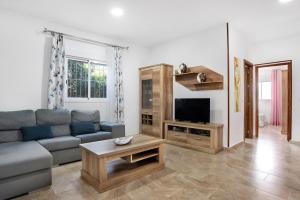 a living room with a couch and a tv at Chalet Rural El Chorrillo in Conil de la Frontera