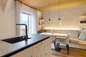 a kitchen with a sink and a dining table at Ferienwohnung Lavendel Thalerhof in Ponte Nova