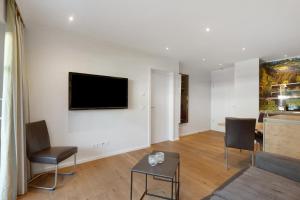 a living room with a flat screen tv on a wall at Hawerländer Apartments in Schmallenberg