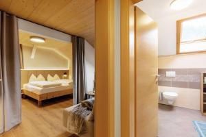 a bedroom with a bed and a bathroom with a mirror at Ferienwohnung Lavendel Thalerhof in Ponte Nova