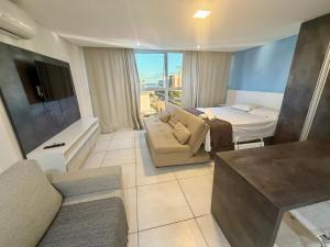 a living room with a couch and a bed at Wind Palace Residence in Cabedelo