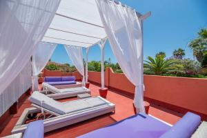 a deck with beds and chairs on a roof at Villa Tessa in Marbella