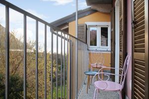 a balcony with two chairs and a table and a window at Il sole di calde Lago Maggiore 505 in Castelveccana