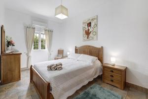 a bedroom with a bed and two night stands and a window at Casa Castelão in Palmela