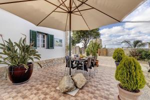 a patio with a table and chairs and an umbrella at Casa Castelão in Palmela