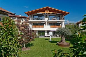 a large building with a balcony and a yard at latemar - schlosserhaus 31 in Tesimo