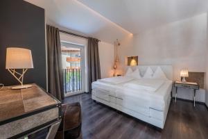 a bedroom with a white bed and a window at latemar - schlosserhaus 31 in Tesimo
