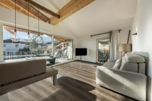 a living room with a couch and large windows at latemar - schlosserhaus 31 in Tesimo