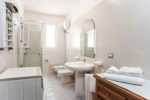 a white bathroom with a sink and a toilet at Piccola casa Marina in Villa San Pietro