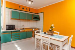 a kitchen with green cabinets and a table with chairs at Piccola casa Marina in Villa San Pietro +15 photos