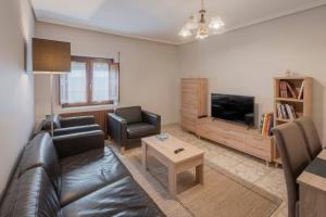a living room with a leather couch and a television at Casa Tilde in Matapozuelos