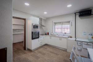 a kitchen with white cabinets and a stove top oven at Casa Tilde in Matapozuelos