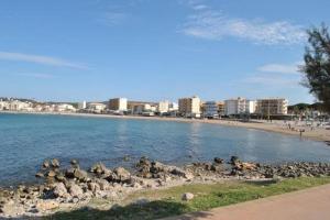 a beach with rocks in the water and buildings at Apartamento luminoso a 100mts playa, ambiente tranquilo in L'Escala