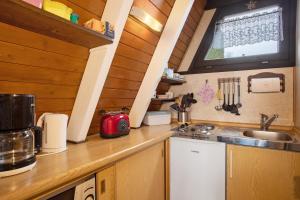 a kitchen with a sink and a counter top at Nurdach-Haus Typ 7 in Immenstaad am Bodensee +13 photos