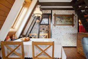 a dining room with a white table and chairs at Nurdach-Haus Typ 7 in Immenstaad am Bodensee