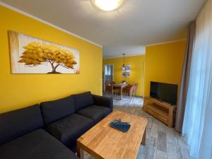 a living room with a blue couch and a tv at Ferienhaus Pirol in Zossen