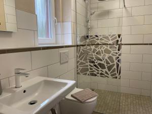 a bathroom with a sink and a toilet and a shower at Ferienhaus Pirol in Zossen +31 photos