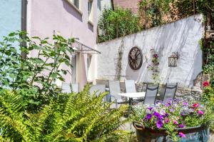 a patio with chairs and a table and flowers at Wein- und Gästehaus Lutz in Iphofen