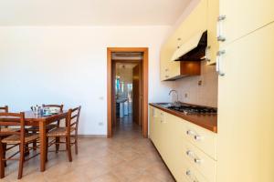 a kitchen with a table and a dining room at Appartamenti Cavour H in Villasimius +15 photos