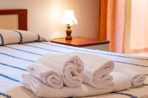 a pile of towels sitting on a bed at Appartamenti Cavour H in Villasimius